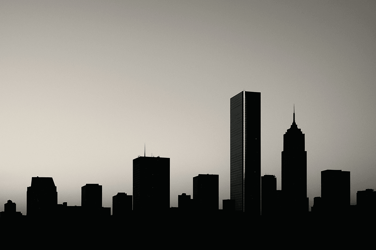 Dramatic monochrome skyline silhouette at dusk with a single distant tower rimmed in steel-blue light